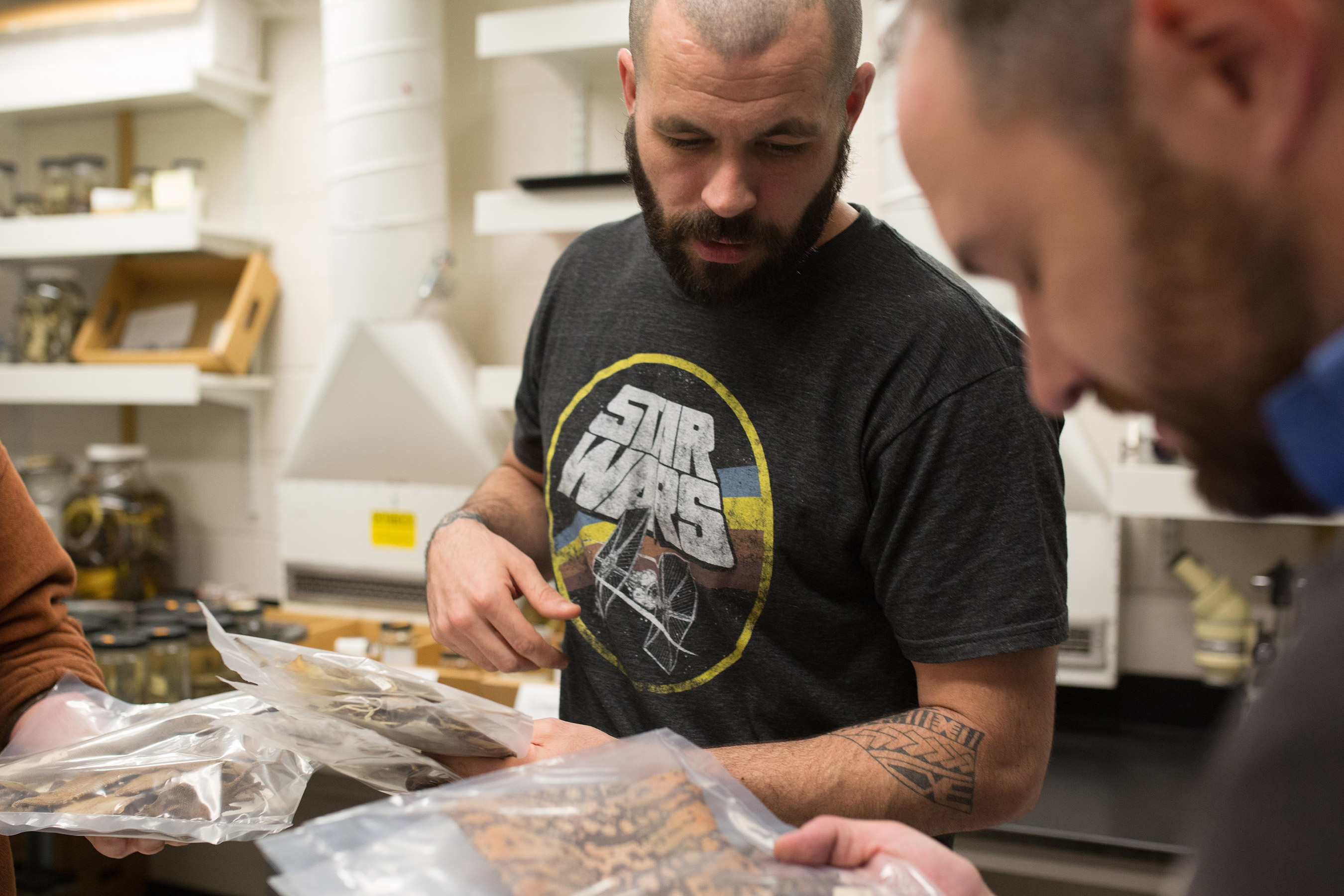 Two male students, looking at a herpetology specimen in a bag